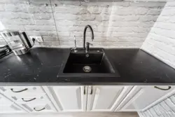 Акси ошхона бо countertop сафед ва танӯраи сиёҳ