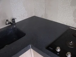Photo of a kitchen with a white countertop and a black sink