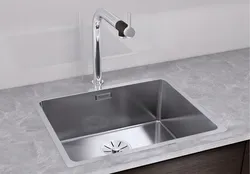 Kitchen sinks built into countertops made of artificial photo