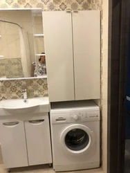 Kir yuvish mashinasi ustidagi hammom kabinetlarining fotosurati