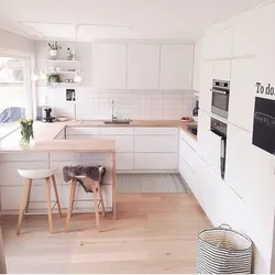 White kitchen in the interior with a wooden countertop real photos