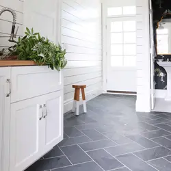 Gray porcelain tiles on the floor in the kitchen interior