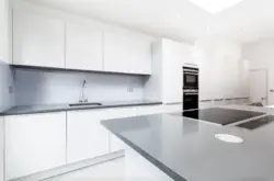Kitchen with a gray countertop and apron in the interior photo