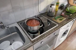 Раковина ва печка дар паҳлӯи якдигар дар акс ошхона
