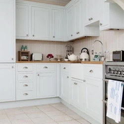 Ошхона сафед бо countertop чӯбӣ ва дастаки сиёҳ дар дохили
