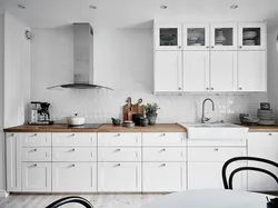 Ошхона сафед бо countertop чӯбӣ ва дастаки сиёҳ дар дохили