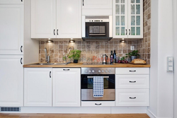 Ошхона сафед бо countertop чӯбӣ ва дастаки сиёҳ дар дохили