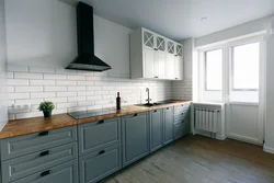 White kitchen with wooden countertop and black handles in the interior