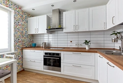Ошхона сафед бо countertop чӯбӣ ва дастаки сиёҳ дар дохили