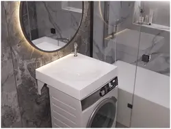 Bathroom design with a sink above the washing machine photo