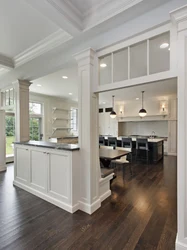 Columns in the interior of a living room with a kitchen