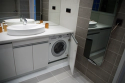 Bathroom design with countertop sink and washing machine