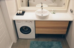 Bathroom design with countertop sink and washing machine