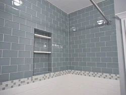 Bathtub with white tiles and gray grout photo