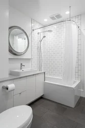 Bathtub with white tiles and gray grout photo