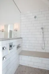 Bathtub with white tiles and gray grout photo