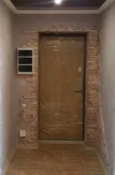 Finishing doors with decorative stone in the hallway photo