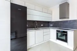 Photo of a kitchen with a black countertop and a black refrigerator