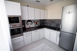 Photo of a kitchen with a black countertop and a black refrigerator