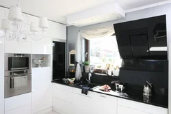 Photo of a kitchen with a black countertop and a black refrigerator
