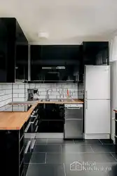 Photo Of A Kitchen With A Black Countertop And A Black Refrigerator