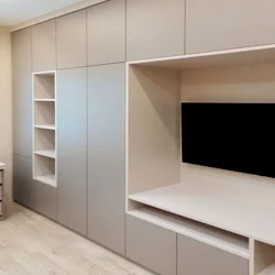 Wardrobe with a niche for a TV in the living room photo