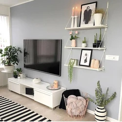 TV ilə divarda oturma otağının daxili hissəsindəki rəflər