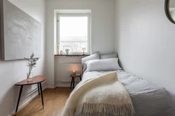 Bed along the wall in a small bedroom design