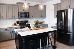 Black refrigerator in the interior of a white kitchen