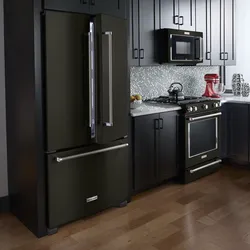 Black refrigerator in the interior of a white kitchen