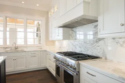 White kitchen with marble countertops in the interior photo