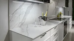 White kitchen with marble countertops in the interior photo