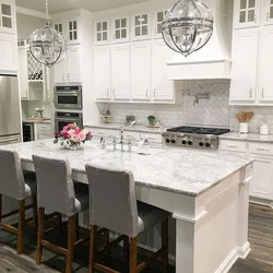 White Kitchen With Marble Countertops In The Interior Photo