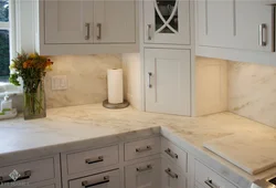 White kitchen with marble countertops in the interior photo