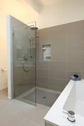 Photo of a bathtub with a shower screen without a tray