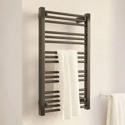 Black heated towel rail in the bathroom interior