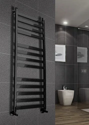 Black heated towel rail in the bathroom interior