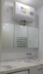 Су жылытқышы бар шағын ванна бөлмесінің фотосы