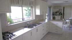 Kitchen design with a window in the middle and a radiator under the window