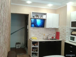 Photo of a small kitchen with a TV