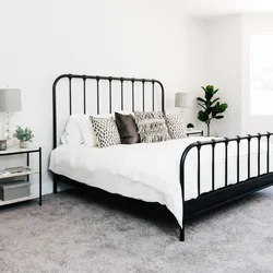 White metal bed in the bedroom interior