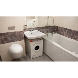 Washing machine in the bathtub under the sink photo