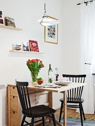 Shelves above the table in the kitchen interior photo