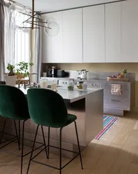 Green chairs in the interior of a white kitchen