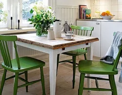 Green chairs in the interior of a white kitchen