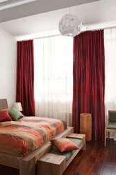 Burgundy curtains in the bedroom interior